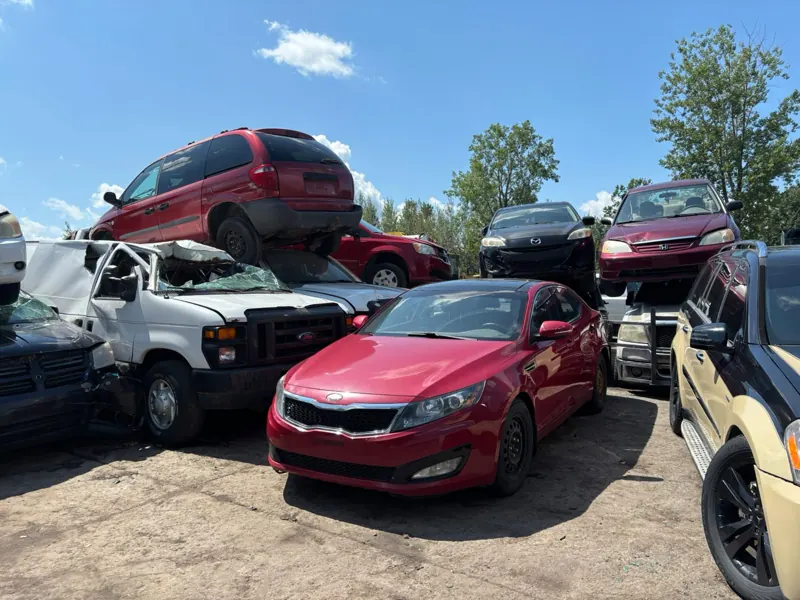Kia rouge, camionnette Ford et minifourgonnettes Dodge dans la cour à scrap de Saint-Jean-sur-Richelieu